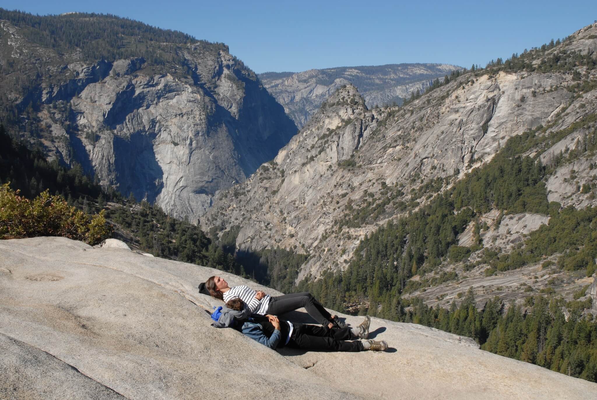 Et par unge mennesker hviler ud i solen efter turen op til Nevada Falls.